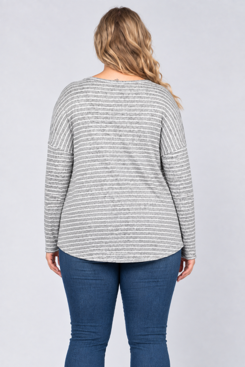 Back studio view of the blonde curvy XL model wearing the gray striped top and blue jeans