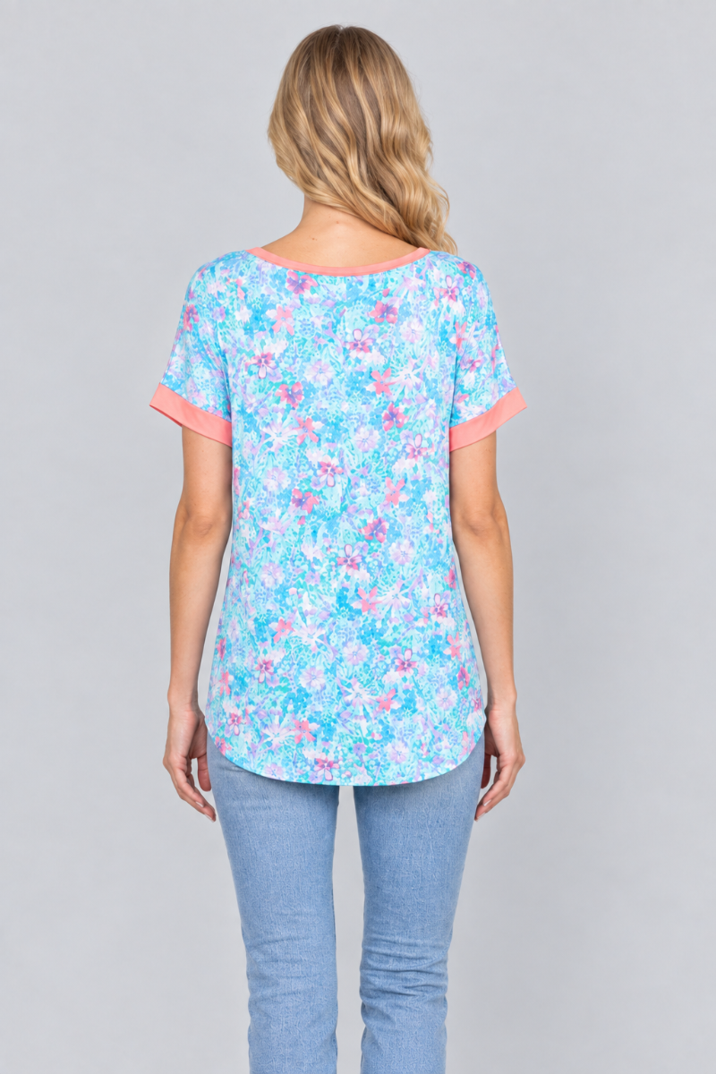 Back studio view of the blonde model wearing the aqua floral top and light-wash jeans