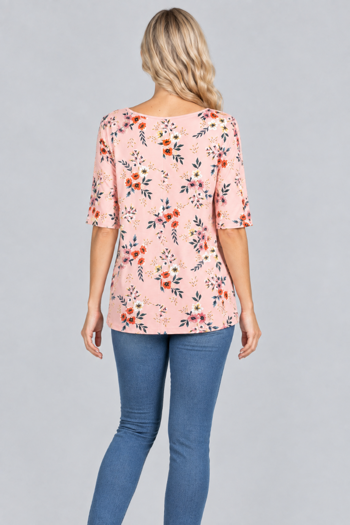 Back studio view of the blonde model wearing the blush-pink floral top and denim jeans