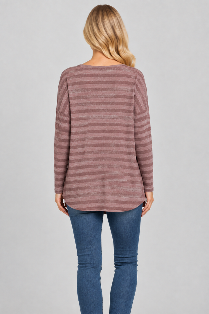 Back studio view of the blonde model wearing the mauve striped top and blue jeans
