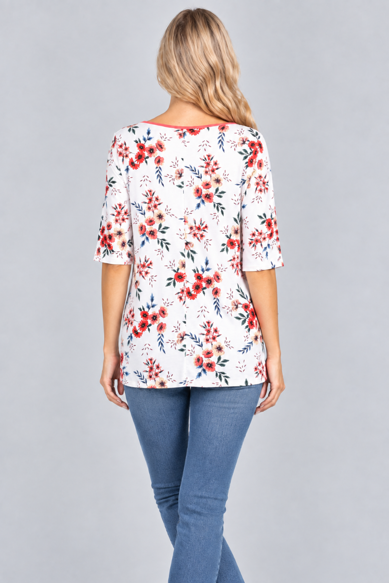 Back studio view of the blonde model wearing the white floral top and denim jeans