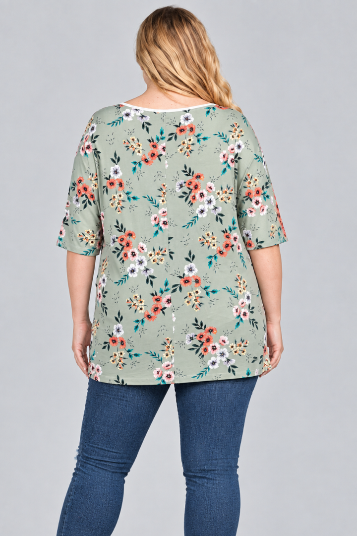 Back studio view of the blonde plus-size model wearing the sage floral tunic and blue jeans