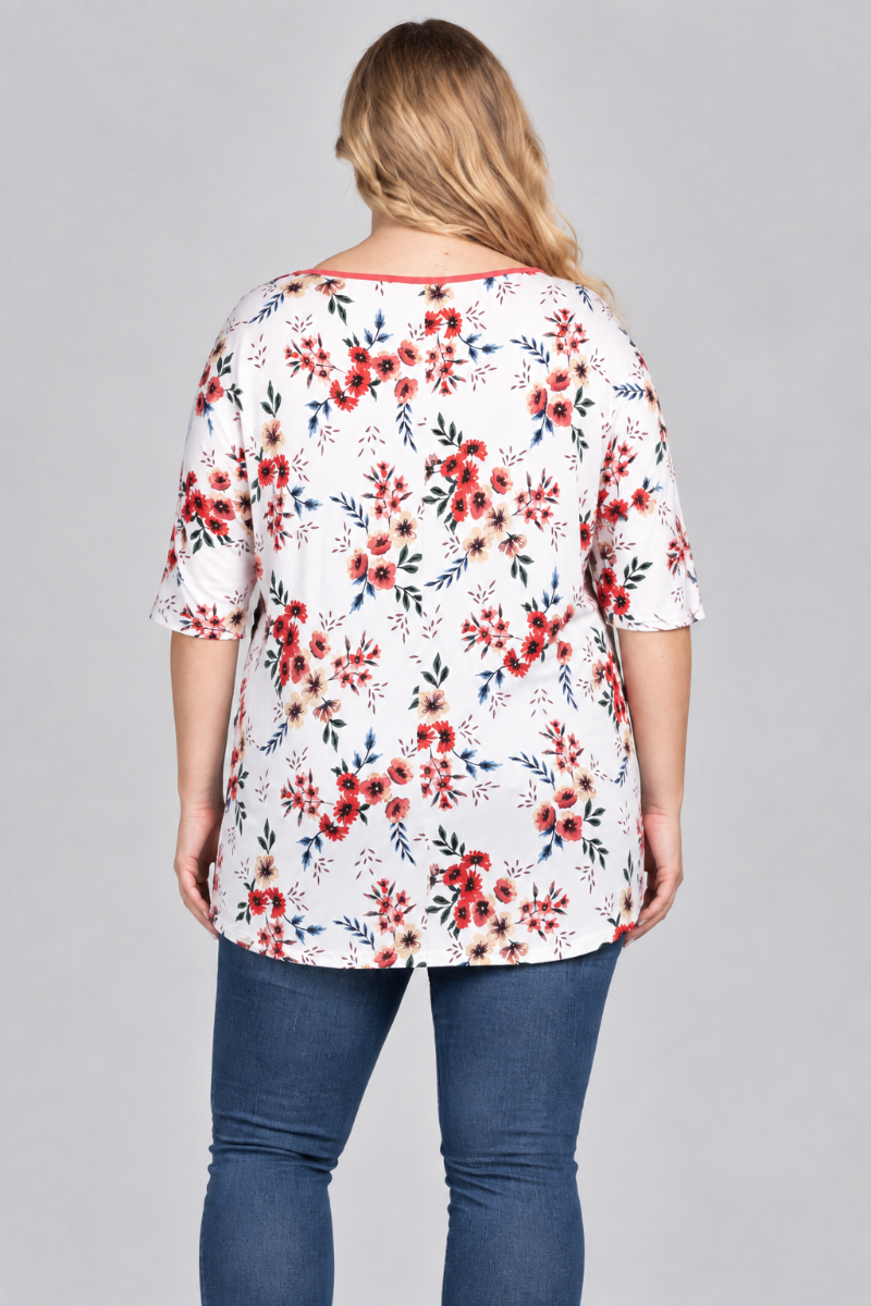 Back studio view of the blonde plus-size model wearing the white floral tunic and blue jeans