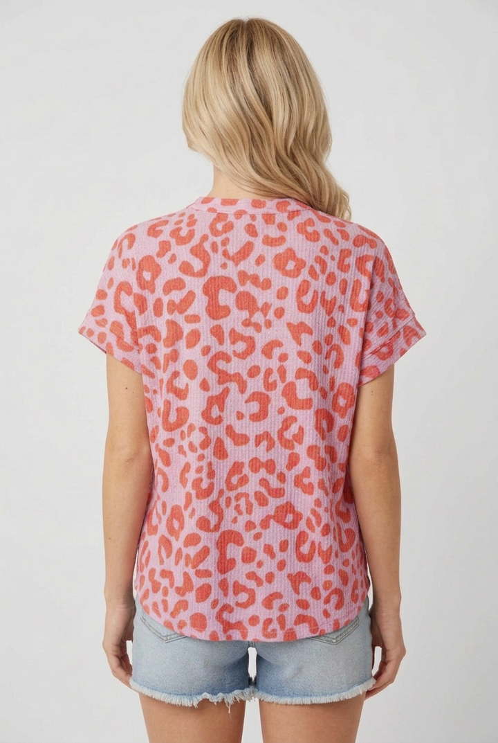 Back view of the blonde model wearing the pink and coral leopard-print top