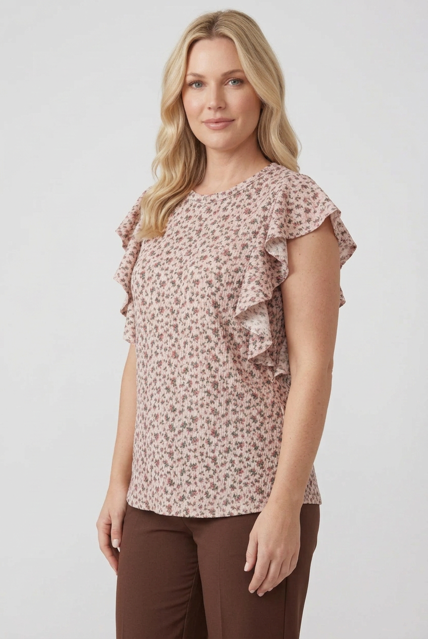 Blonde model in a side pose wearing the pink floral top and brown pants