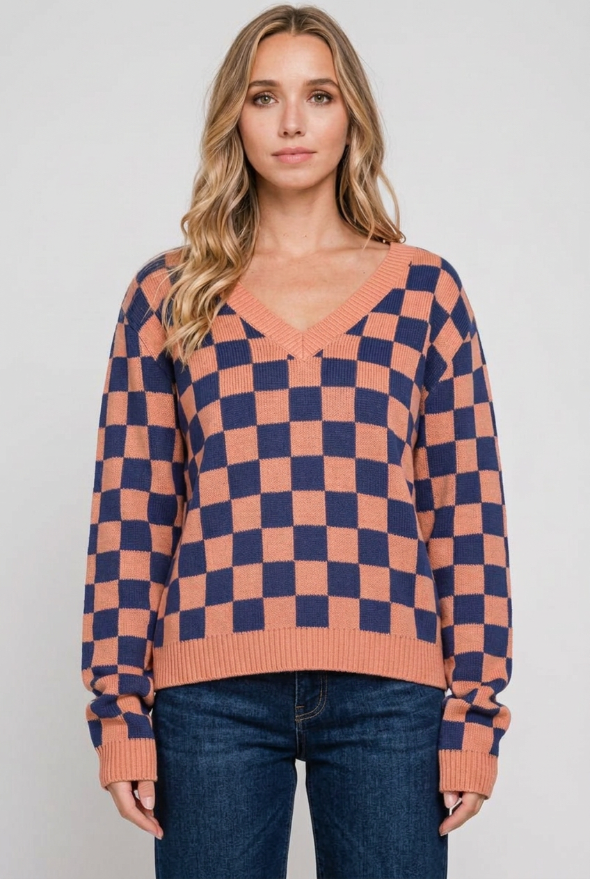 Blonde model wearing the checkerboard sweater with dark-wash jeans