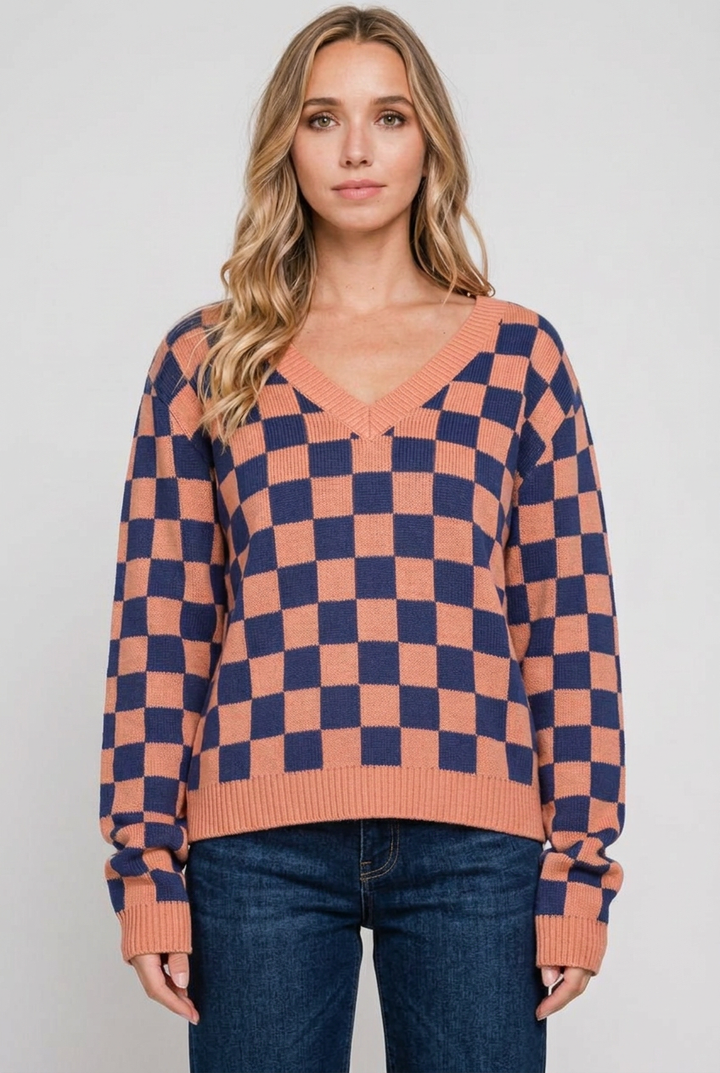 Blonde model wearing the checkerboard sweater with dark-wash jeans