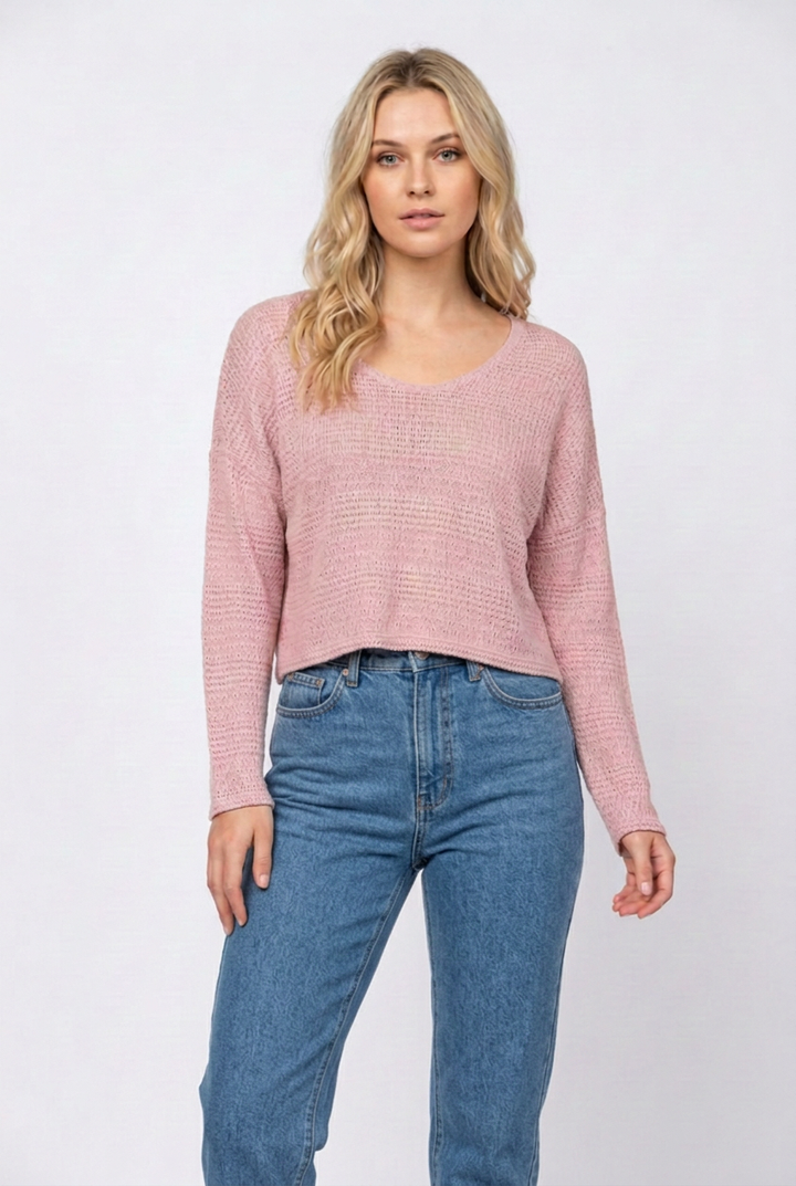 Blonde model wearing the dusty-pink sweater with denim jeans and no necklace