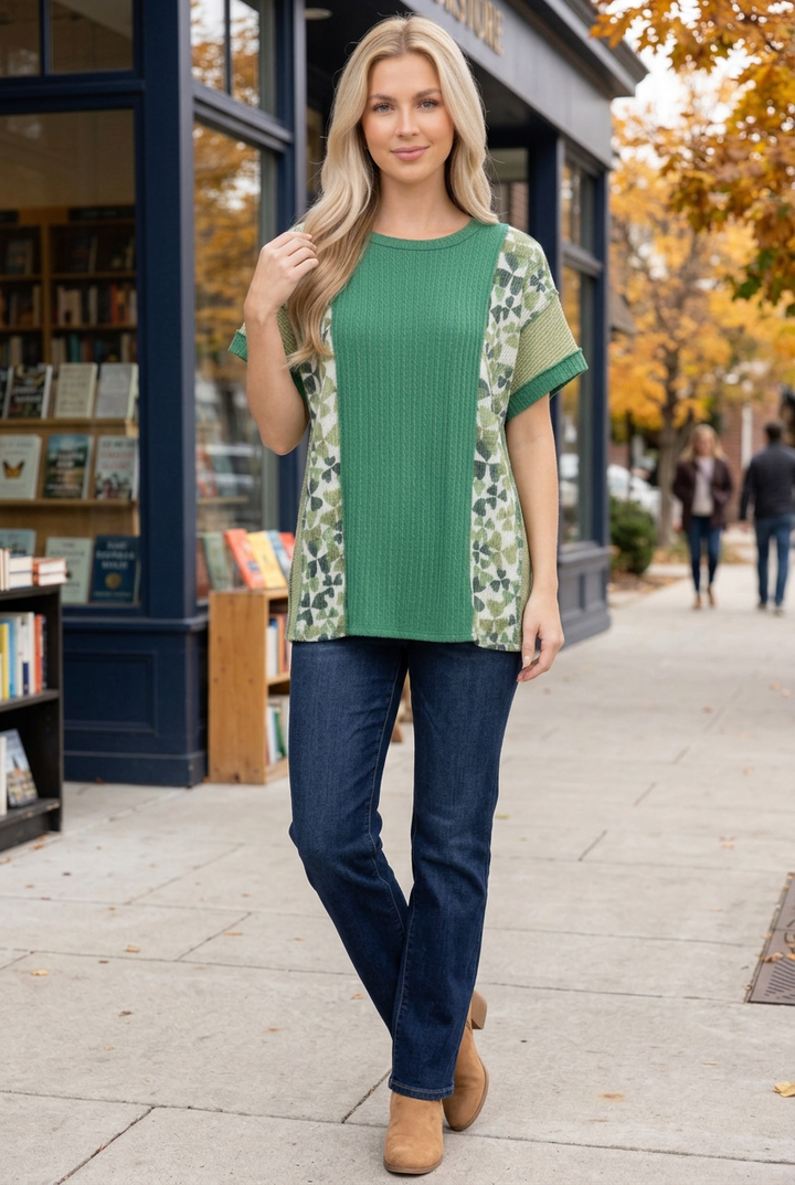 Blonde model wearing the green top and jeans outside an autumn bookstore