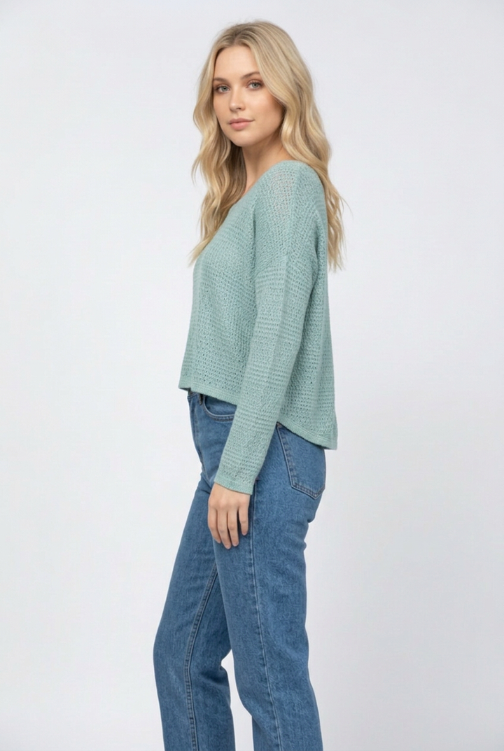 Clear side studio view wearing the teal sweater and denim jeans