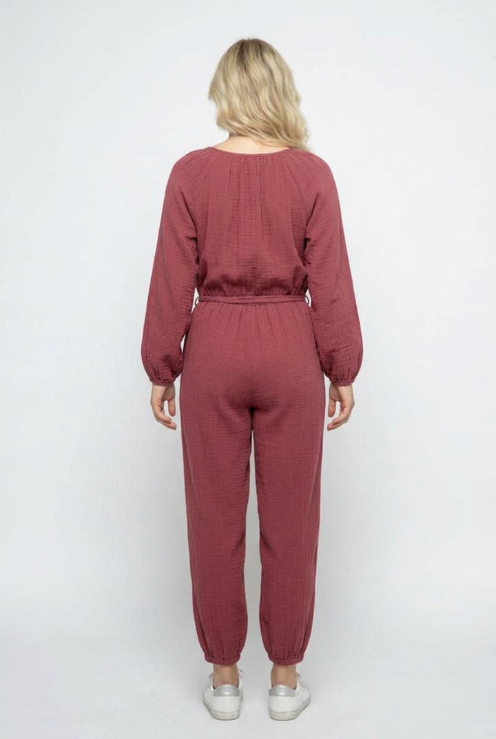 Full-back studio view of the dusty-rose jumpsuit with white sneakers