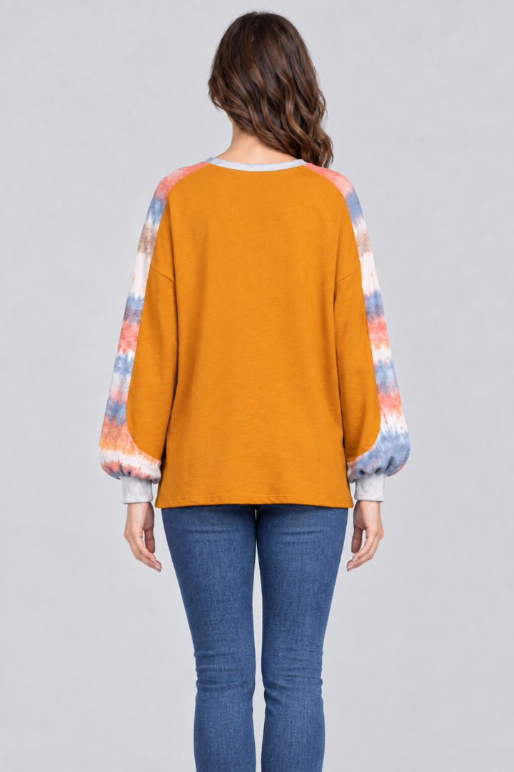 Full-back studio view of the mustard-orange top with tie-dye sleeves