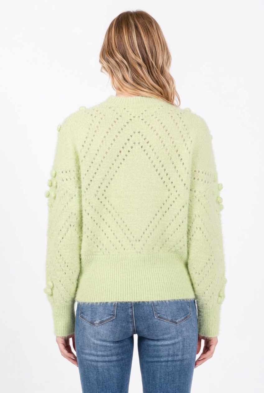Full-back studio view of the pale green diamond-knit sweater