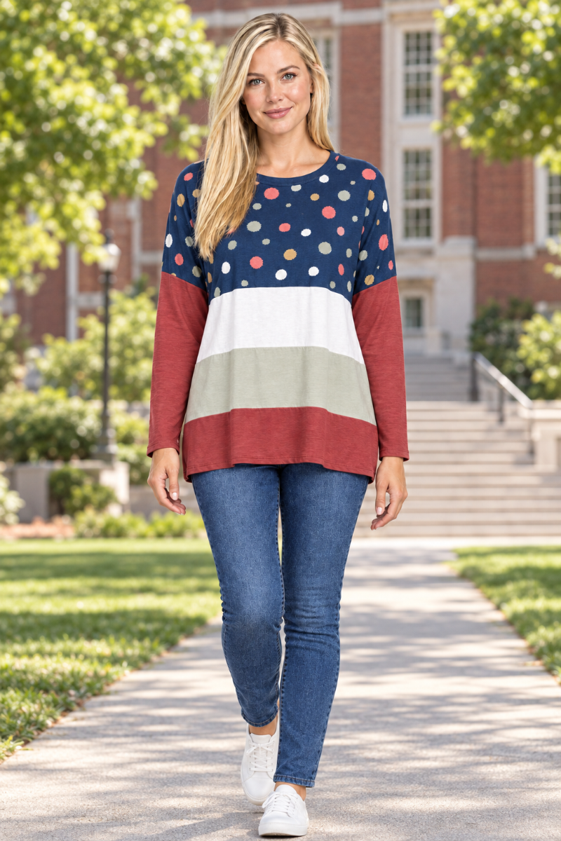 Full-body front view of blonde model in navy dotted color-block tunic and jeans on a university campus quad