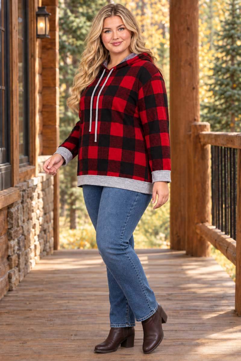 Full-body half-side lifestyle view of a plus-size blonde model wearing the plaid hoodie, blue jeans, and ankle boots