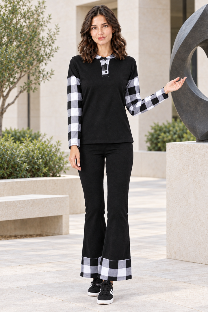 Full-body lifestyle front view, black outfit with black-and-white plaid accents, sculpture courtyard