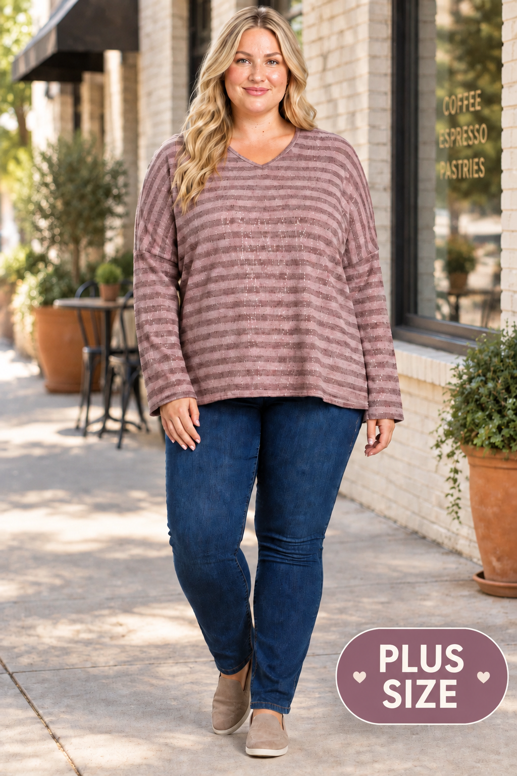 Full-body lifestyle front view, blonde plus-size model in mauve striped top and dark jeans, downtown café sidewalk