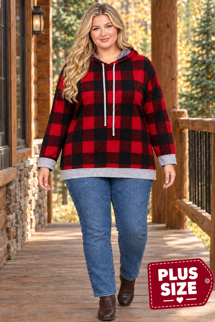 Full-body lifestyle front view of a plus-size blonde model wearing the red-and-black plaid hoodie, blue jeans, and ankle boots