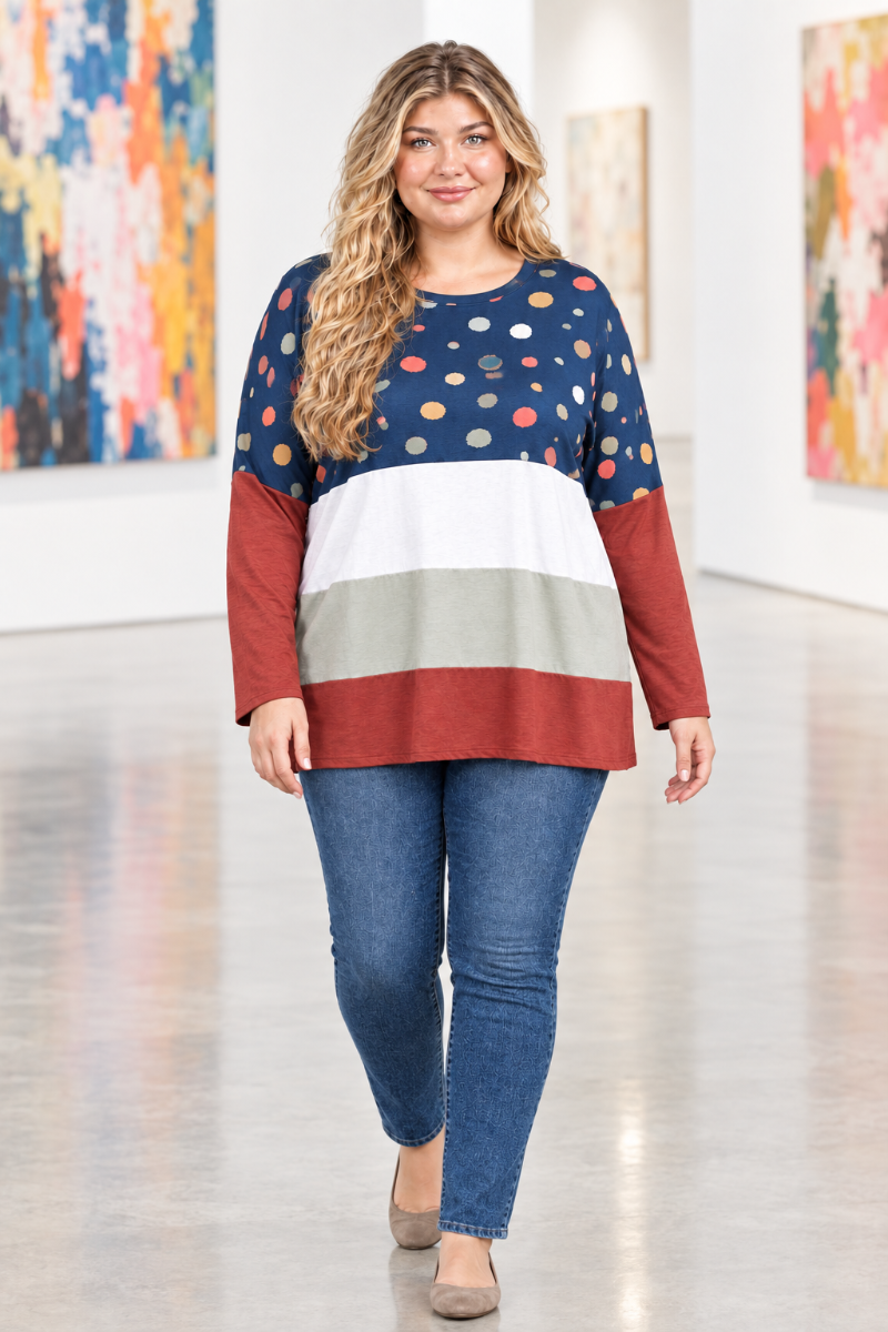 Full-body lifestyle front view of blonde model in navy dotted color-block tunic and blue jeans in a modern art gallery