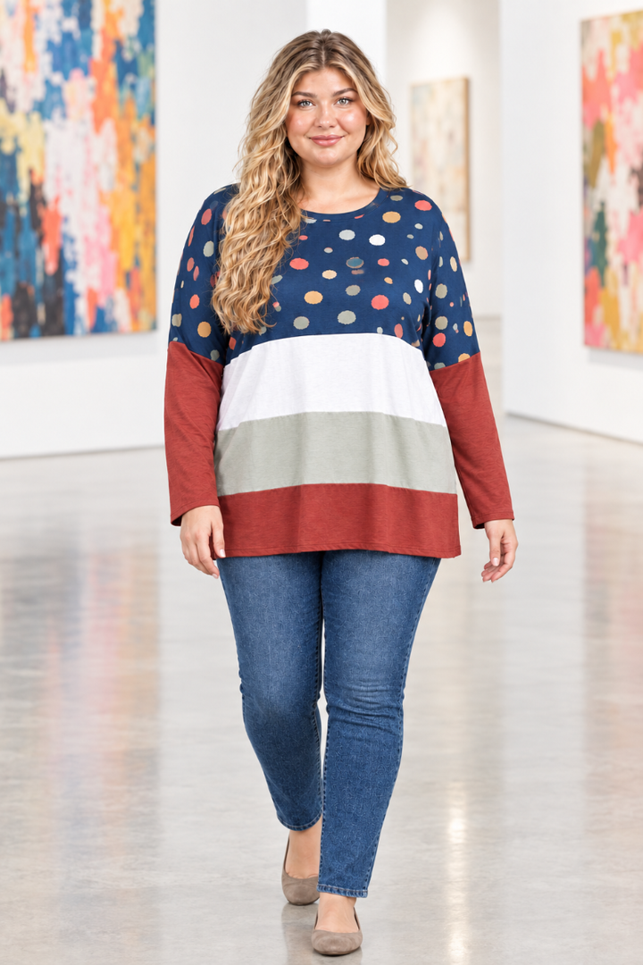 Full-body lifestyle front view of blonde model in navy dotted color-block tunic and blue jeans in a modern art gallery