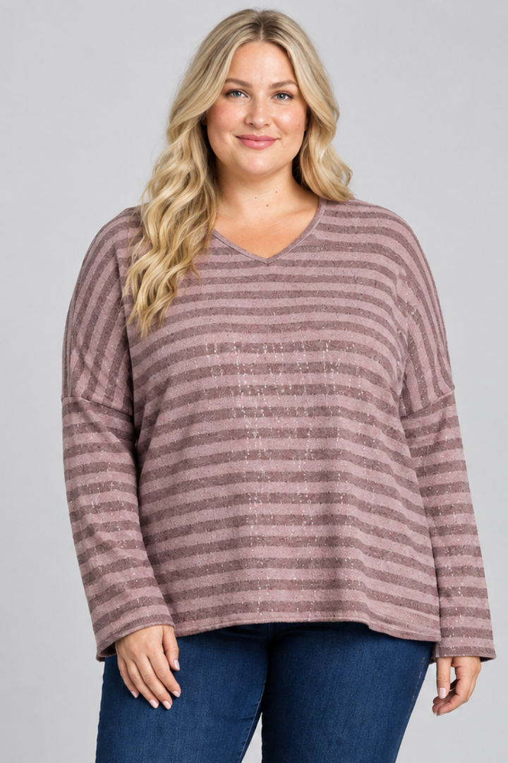 Full-body studio front view, blonde plus-size model in mauve striped top and dark jeans