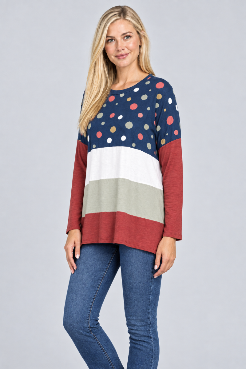 Hat-free studio side view of blonde model in navy dotted color-block tunic and jeans