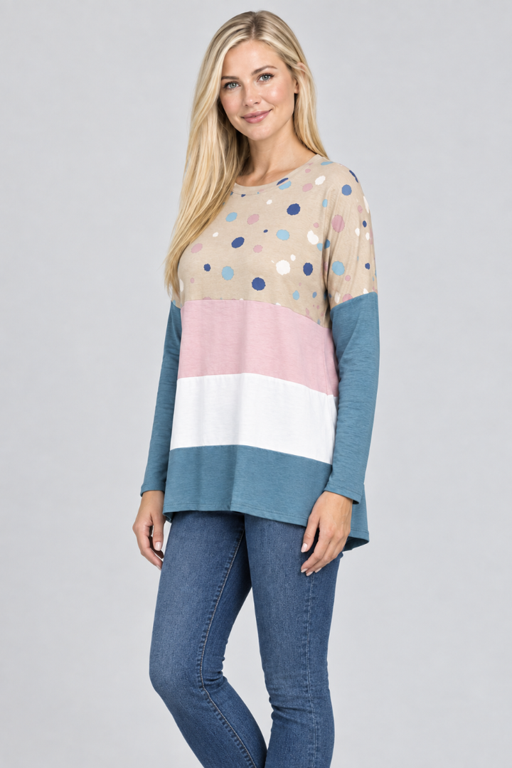 Hat-free studio side view of blonde model in taupe dotted color-block tunic and jeans