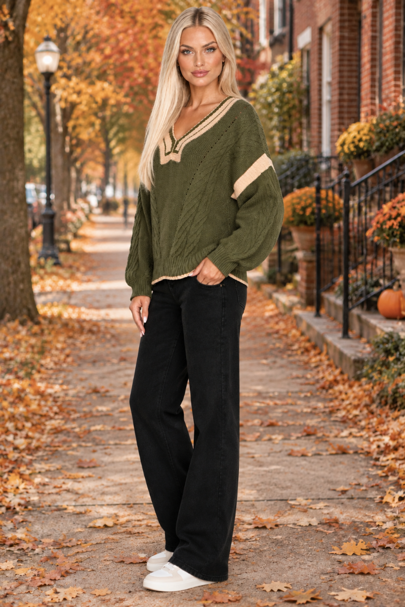 Olive sweater, black pants, blonde model, half-side pose, autumn street background