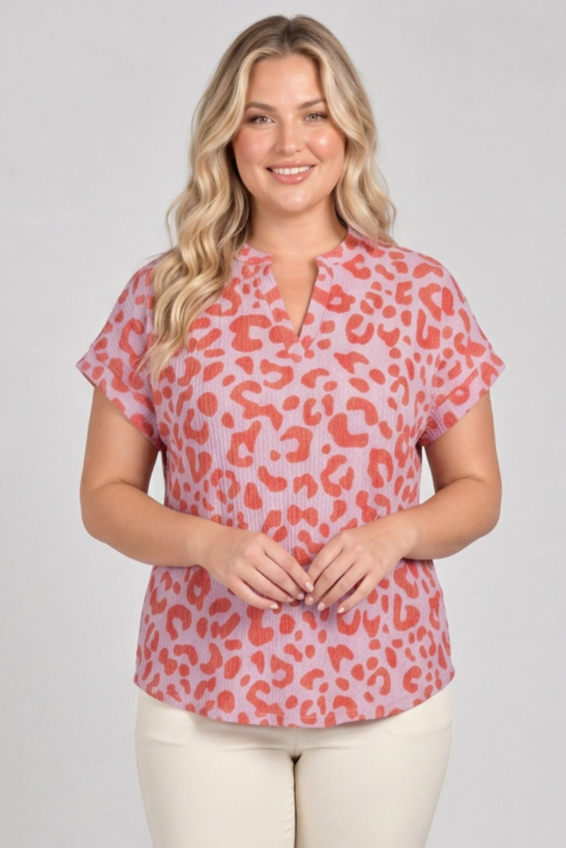 Plus-size blonde model wearing the pink and coral top with cream pants