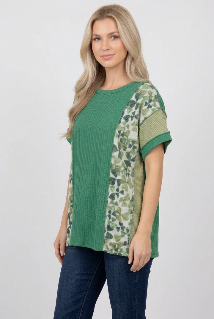 Regular-size blonde model in a side pose wearing the green top and jeans
