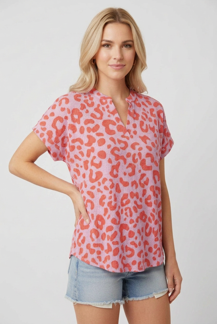 Regular-size blonde model in a side pose wearing the pink and coral top