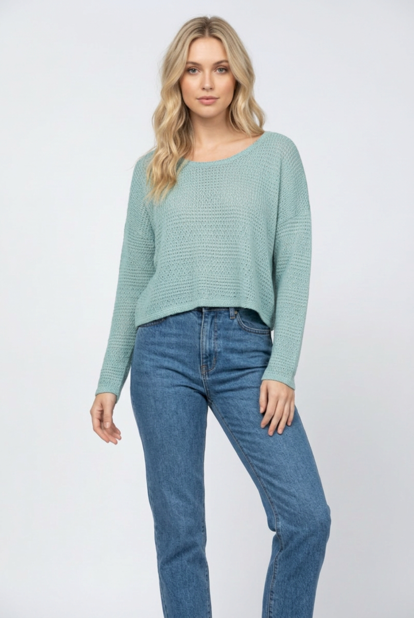 Regular-size blonde model wearing the teal knit sweater with denim jeans and no necklace