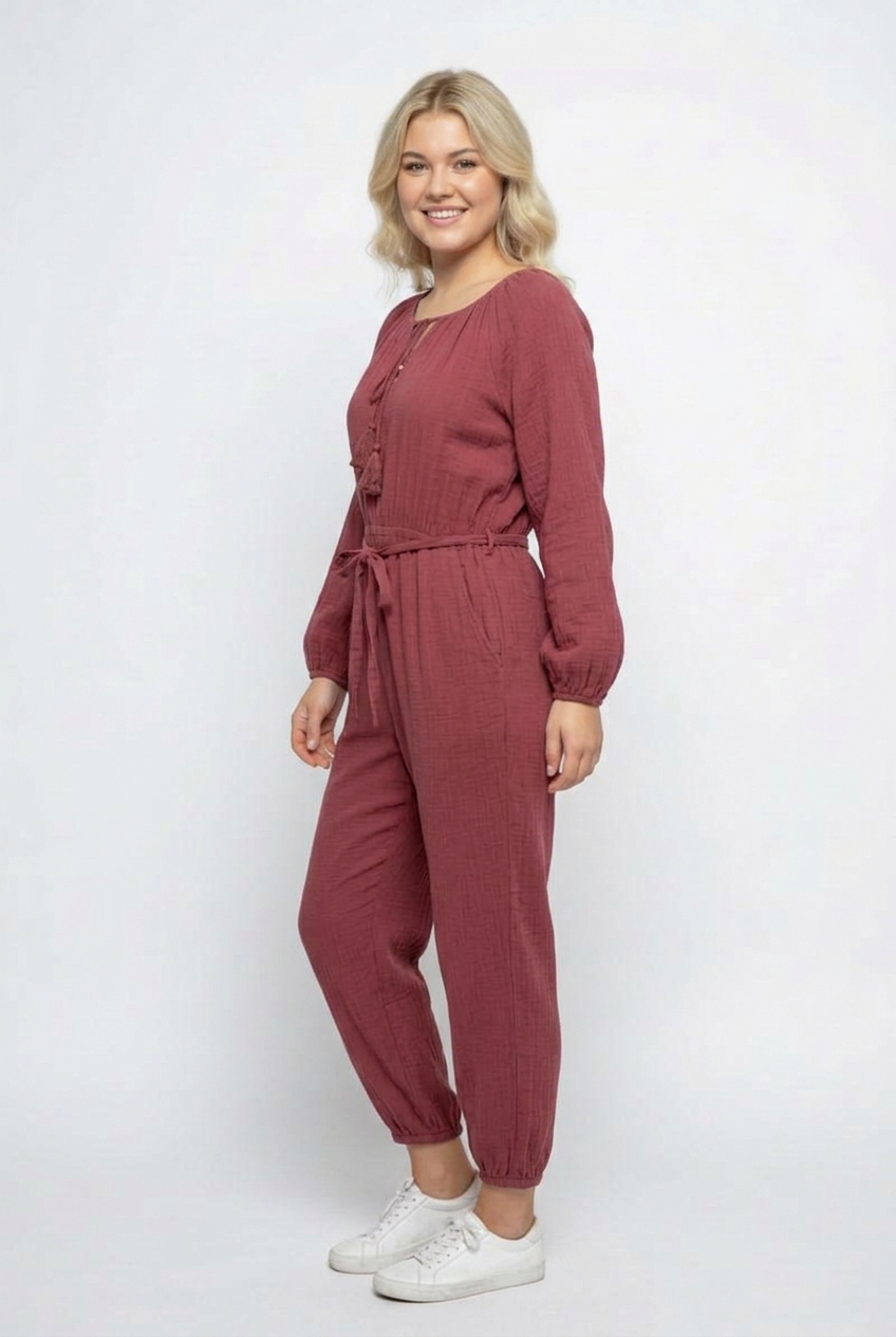 Side studio pose of the approved blonde model wearing the dusty-rose jumpsuit