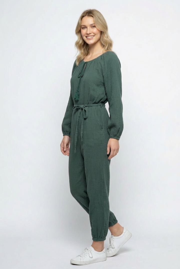 Side studio pose wearing the forest-green jumpsuit