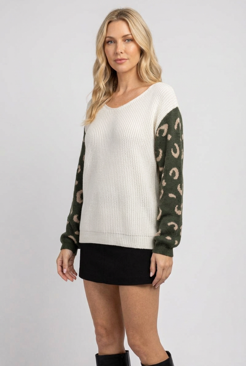 Side studio pose wearing the ivory and olive sweater with black skirt