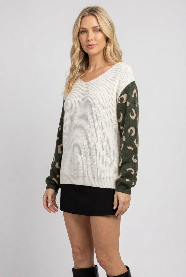 Side studio pose wearing the ivory and olive sweater with black skirt