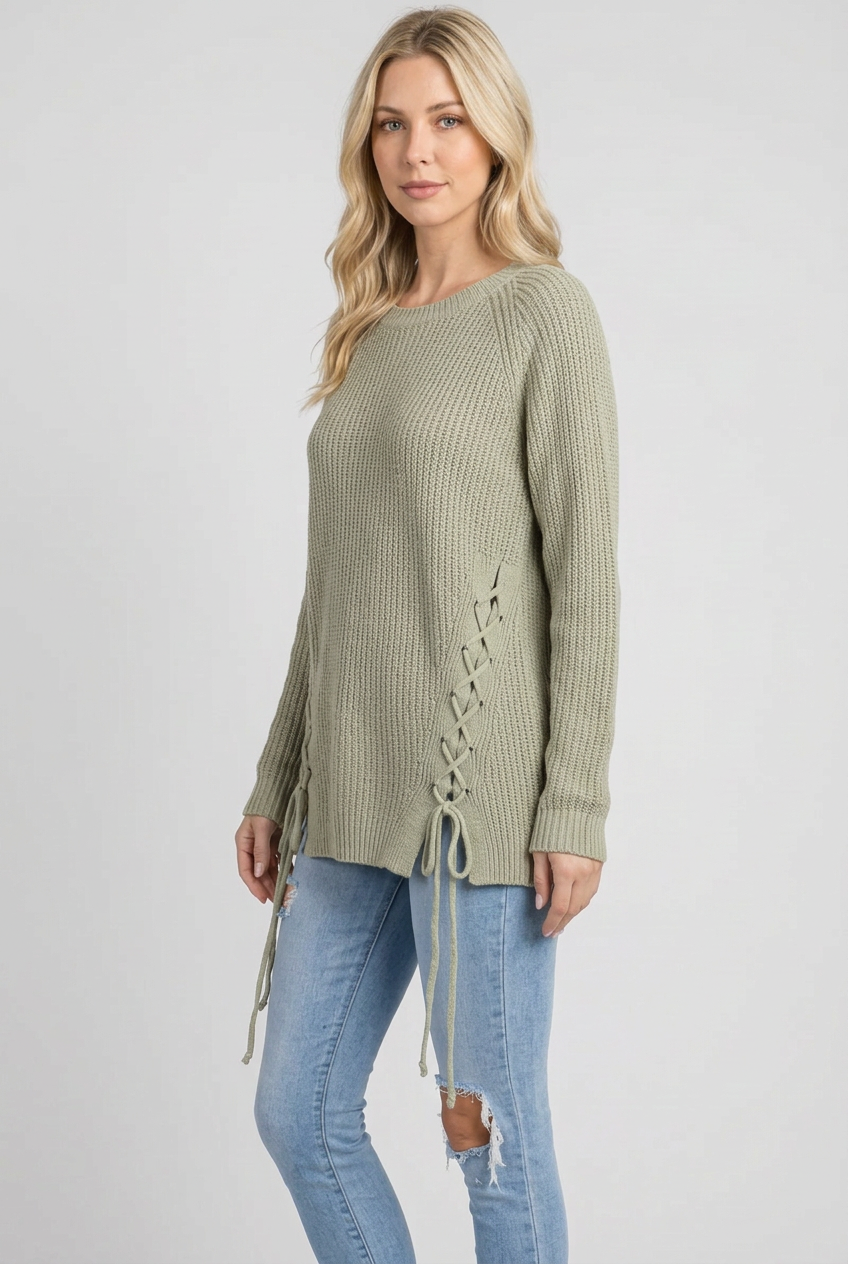 Side studio pose wearing the sage lace-up sweater