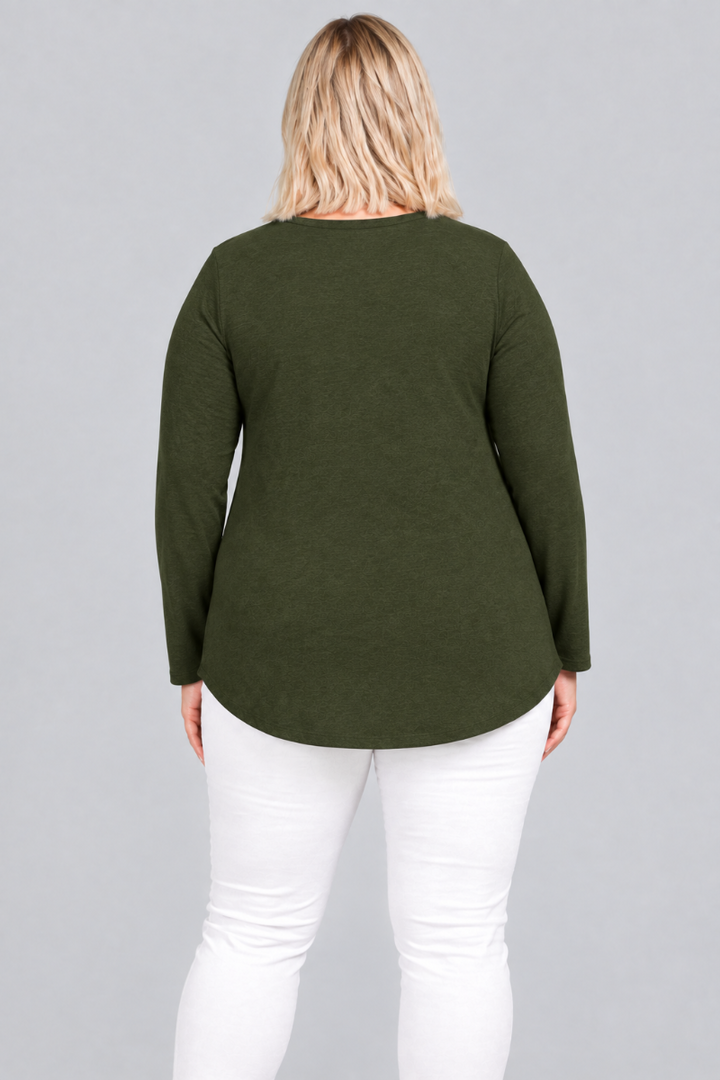 Studio back view of blonde model in dark olive tunic and white pants