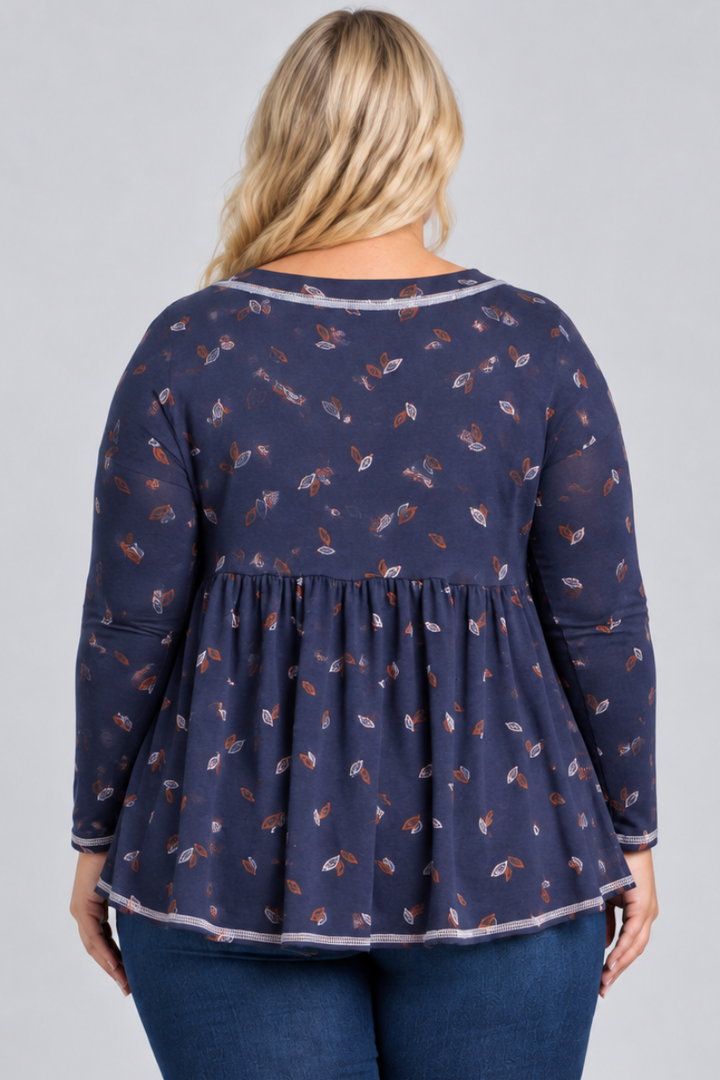 Studio back view of blonde model in navy leaf-print blouse and dark jeans