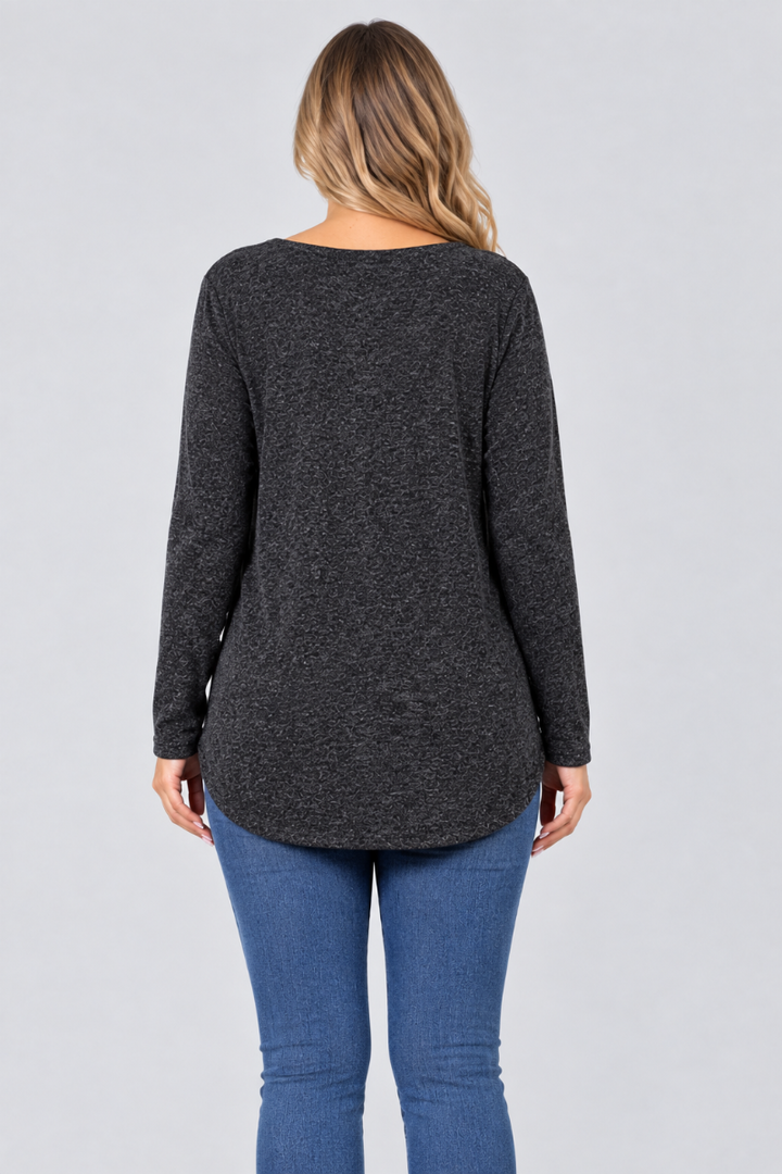 Studio back view of new blonde model in heather-charcoal tunic and blue jeans