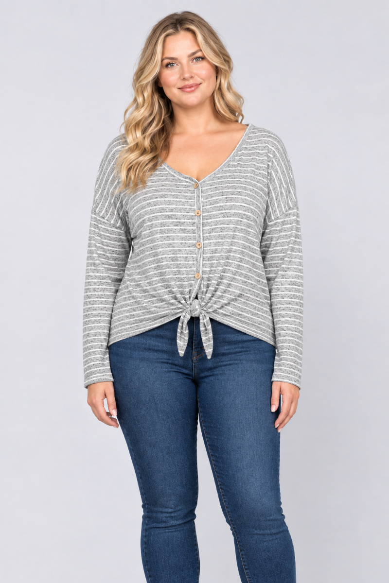 Studio front view of a blonde curvy XL model wearing the gray striped button-front tie-hem top and blue jeans