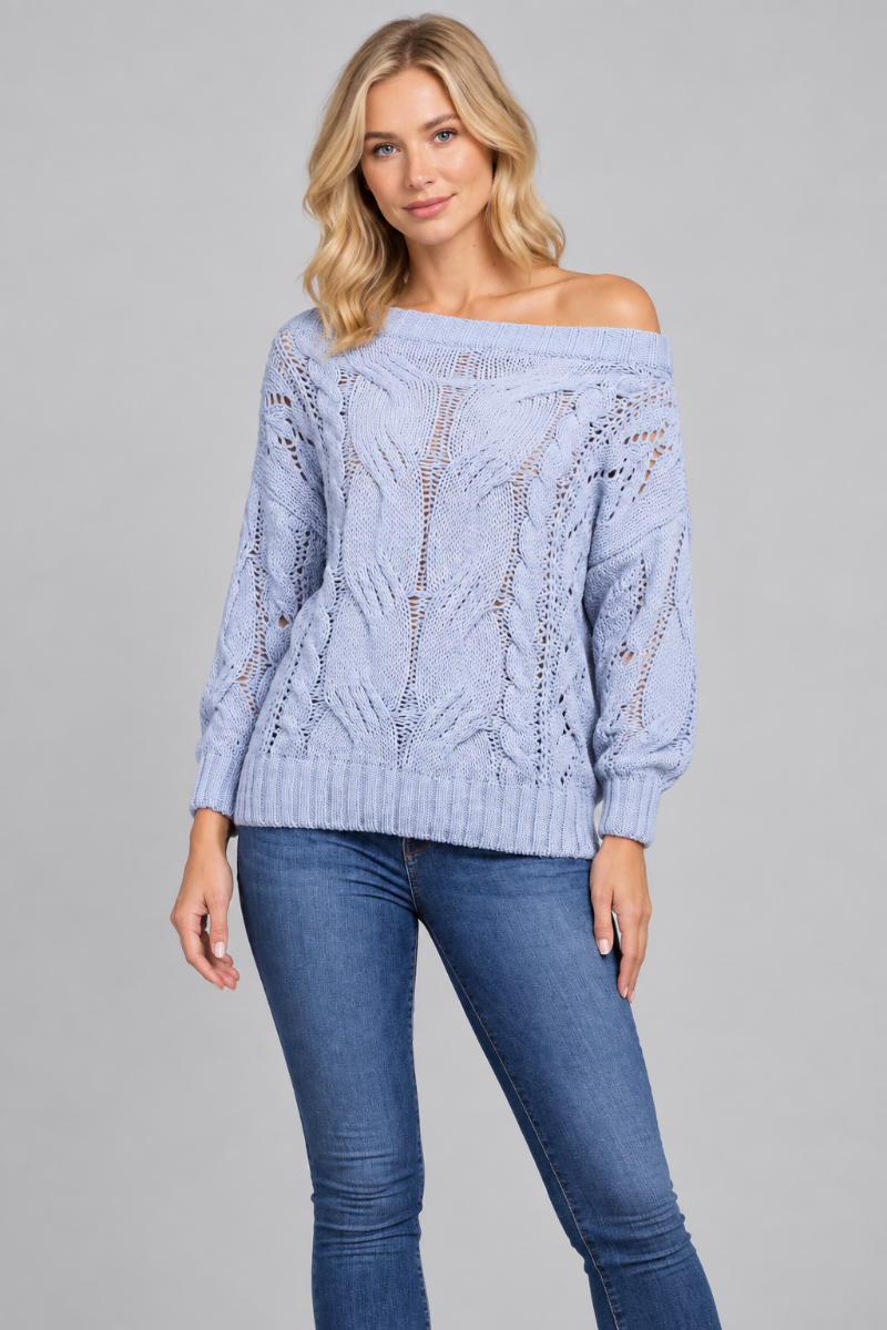 Studio front view of a blonde model wearing the pale-blue off-shoulder open-knit sweater and blue jeans