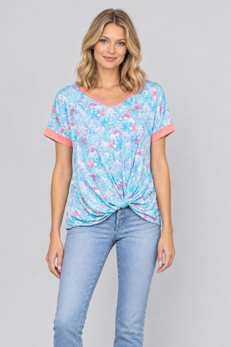 Studio front view of a new blonde model wearing the aqua floral twist-front top and light-wash jeans