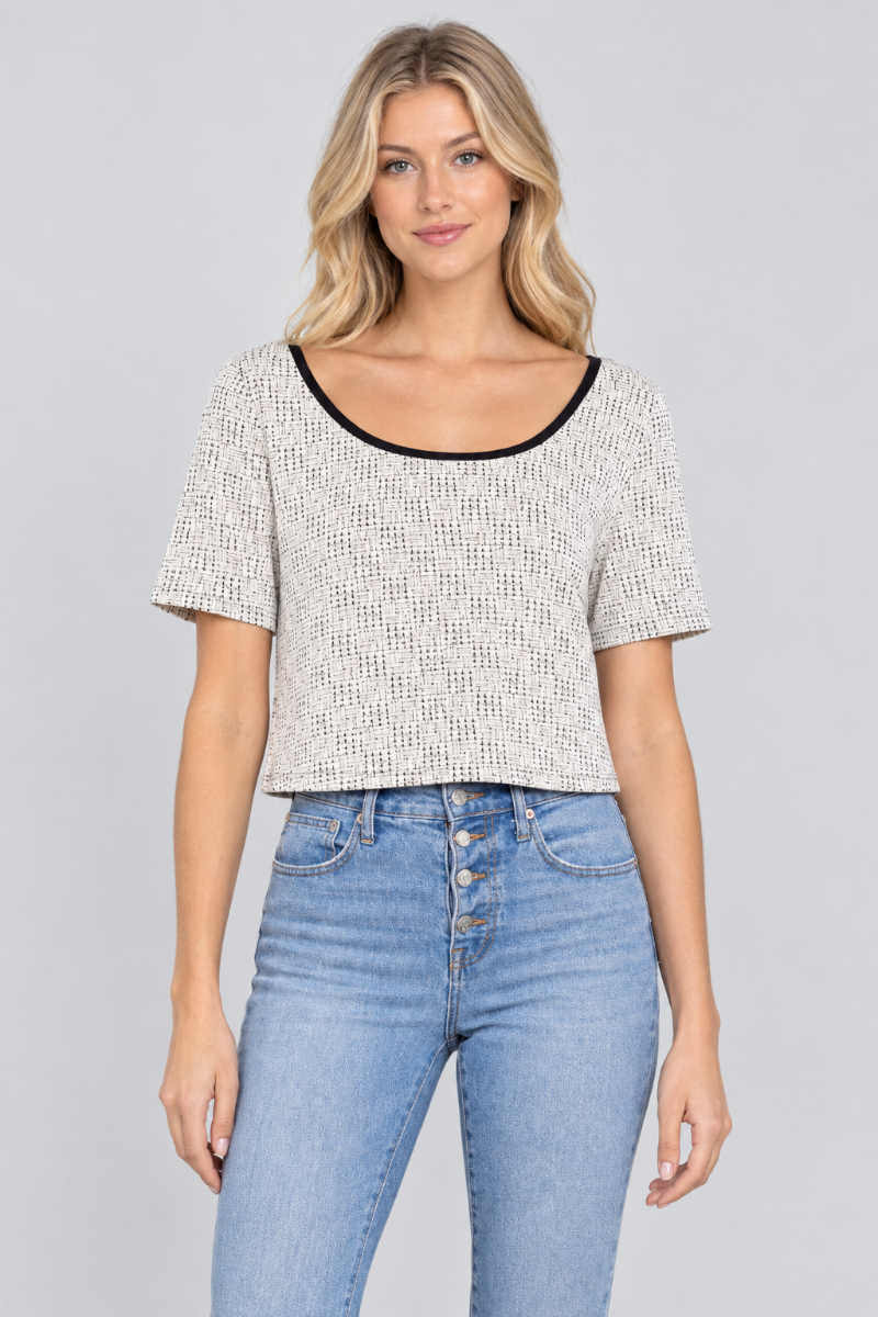 Studio front view of a new blonde model wearing the ivory micro-print crop top and light-wash jeans