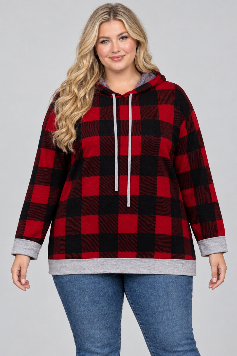 Studio front view of a new plus-size blonde model wearing the red-and-black plaid hoodie and blue jeans