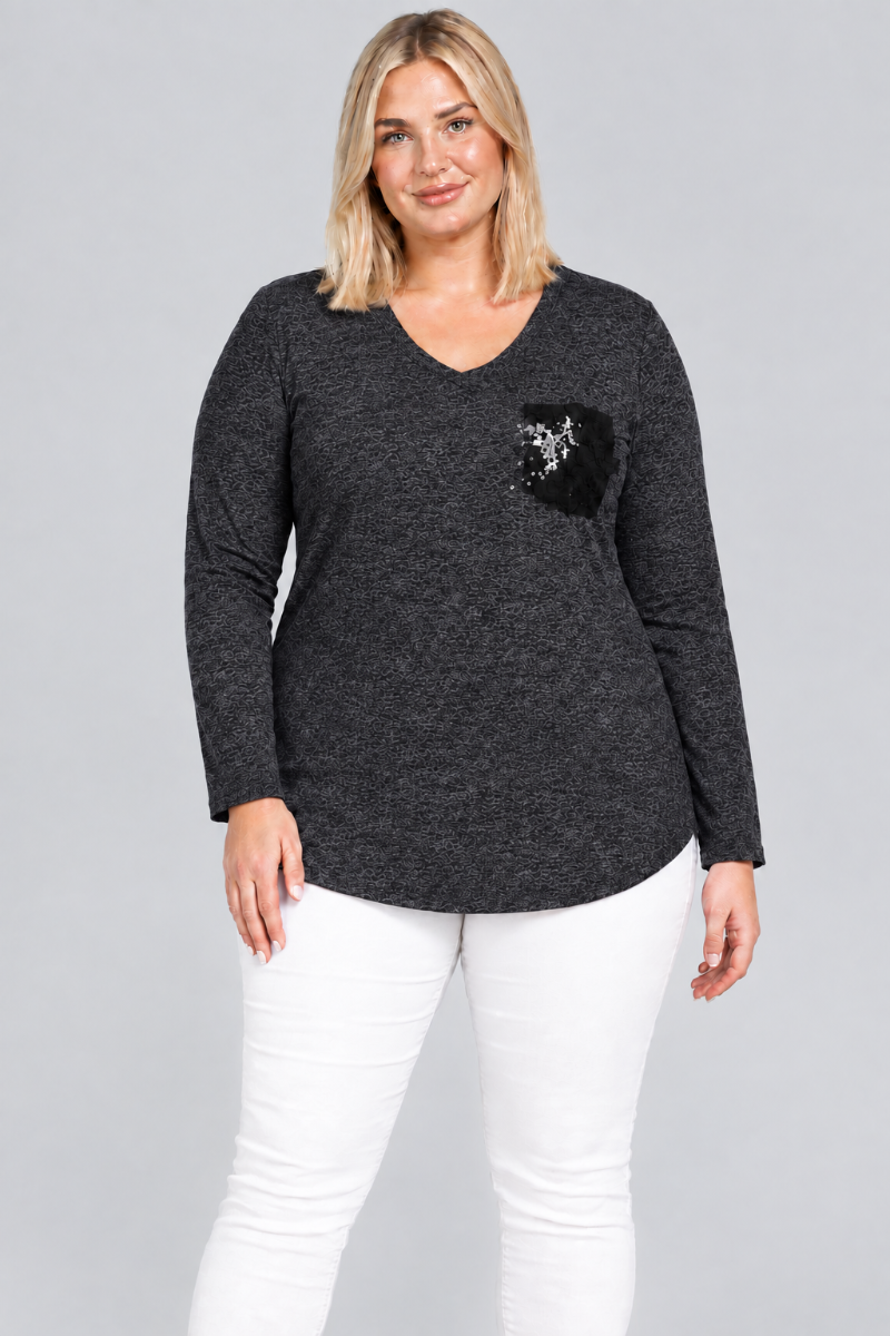 Studio front view of blonde model in charcoal V-neck tunic with black embellished pocket and white pants