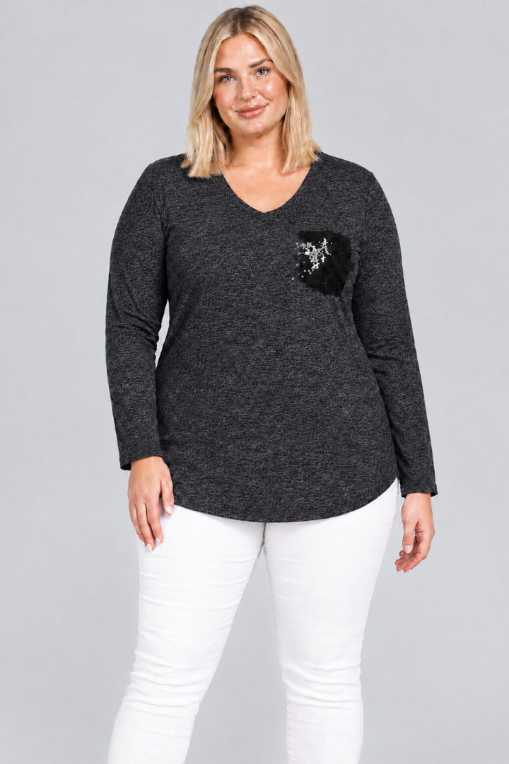 Studio front view of blonde model in charcoal V-neck tunic with black embellished pocket and white pants