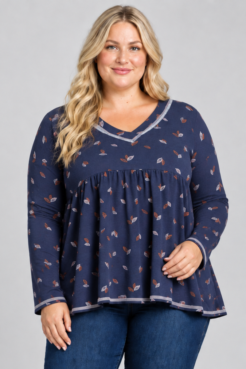 Studio front view of blonde model in navy leaf-print blouse with contrast trim and dark jeans