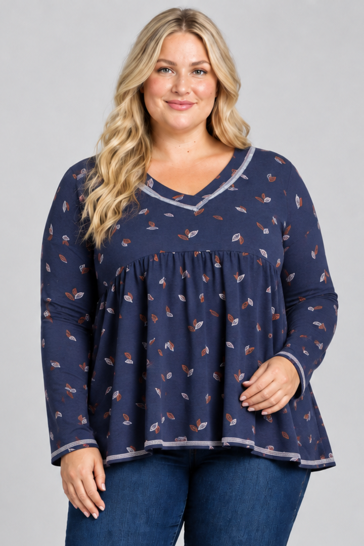 Studio front view of blonde model in navy leaf-print blouse with contrast trim and dark jeans