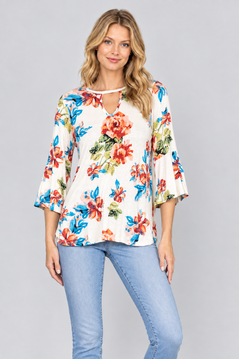 Studio front view of the blonde model wearing the ivory floral keyhole blouse and light-wash jeans